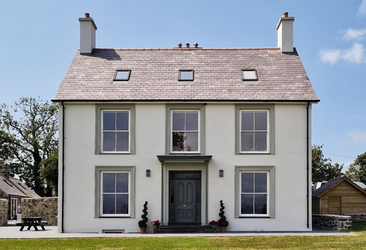 Stone house with sash windows and a dark entrance door