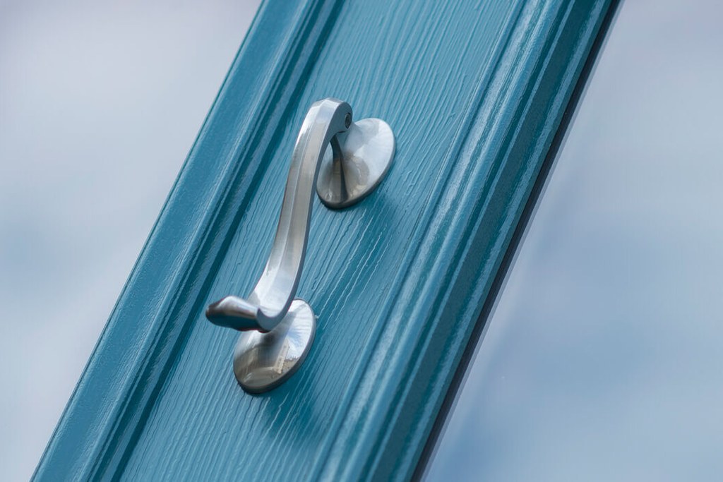 Blue entrance door with glazed panels and a metal handle