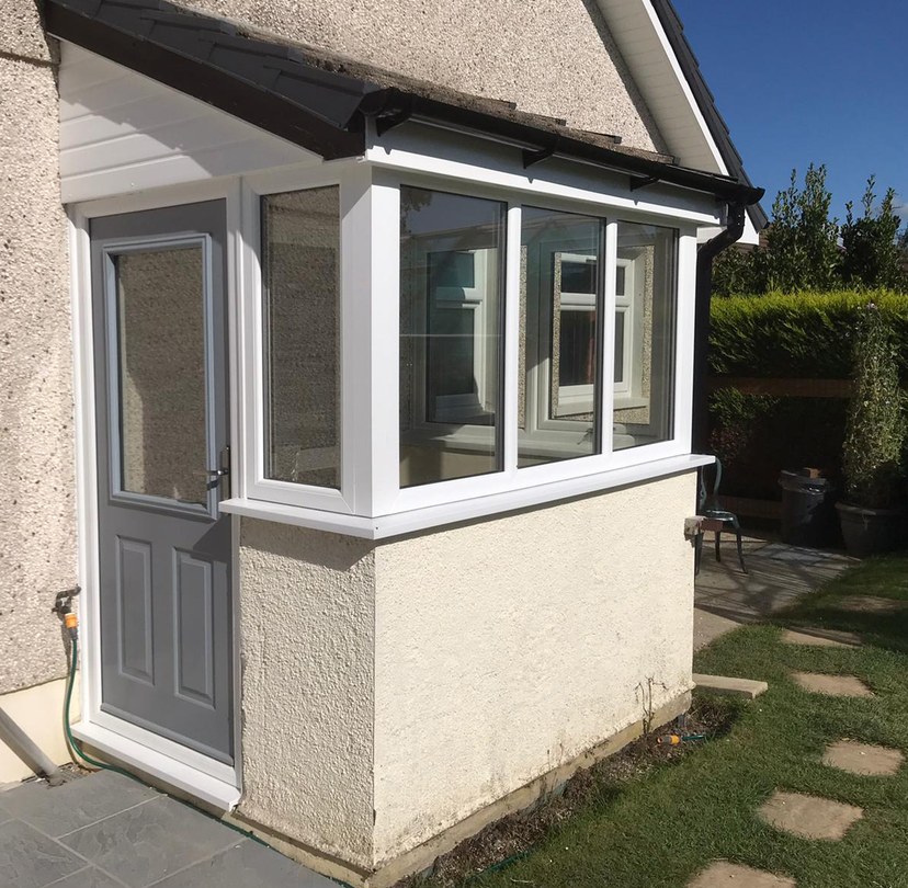 White glazed porch fitted to a rendered home