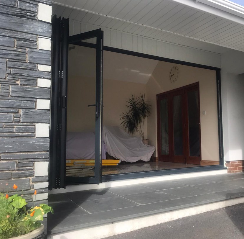 Dark-framed bi-folding doors opened onto a patio