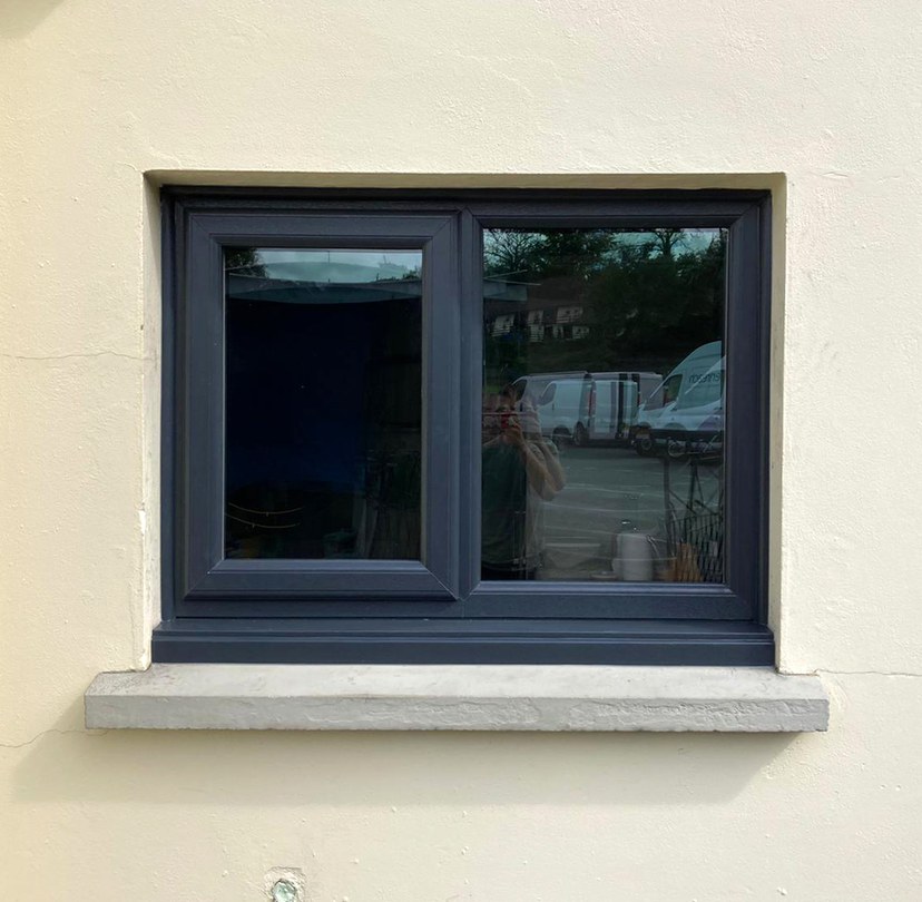 Dark-framed window installed in a rendered wall