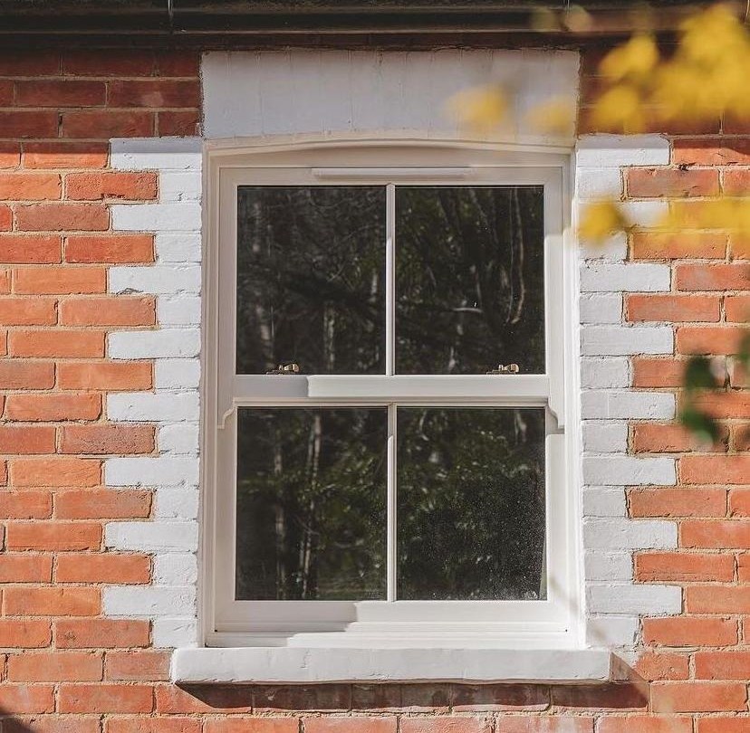 Grey sash window installed in a red-brick wall