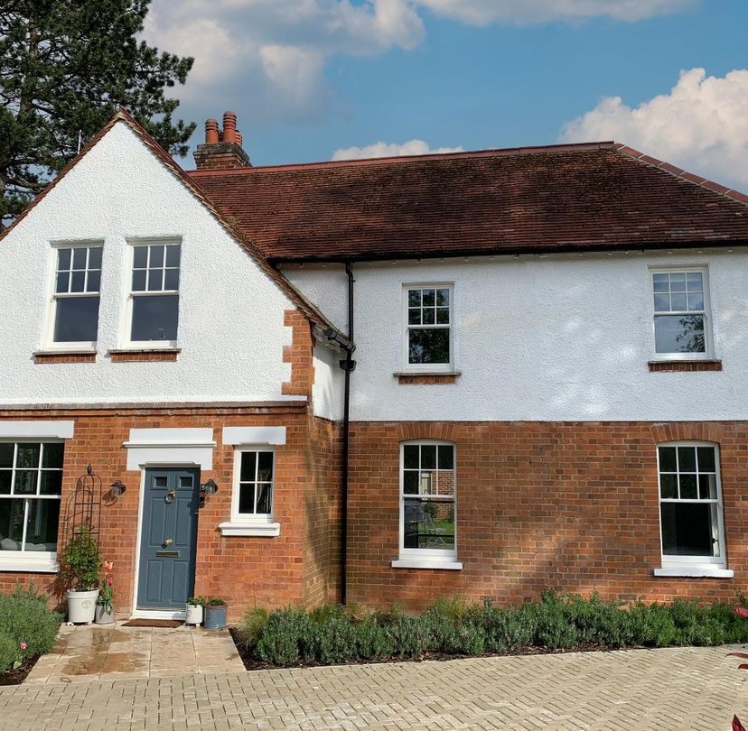 White windows installed across a red-brick home